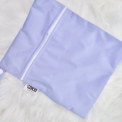 Each backpack purchase includes a free waterproof bag. This image shows the waterproof bag in purple, with a zip closure.