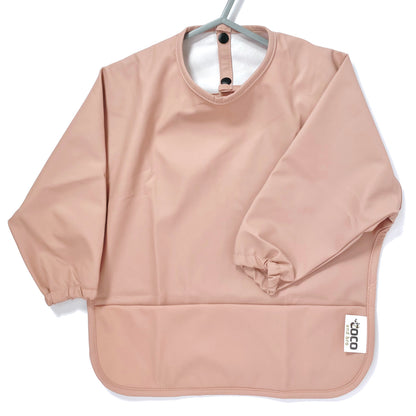 Long-sleeve kids apron in rose pink colour, showing front view.