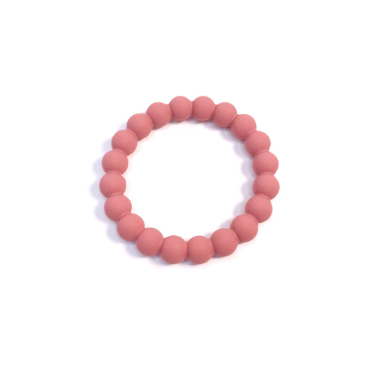 A pink beaded silicone teething ring. Can be worn as a bracelet.