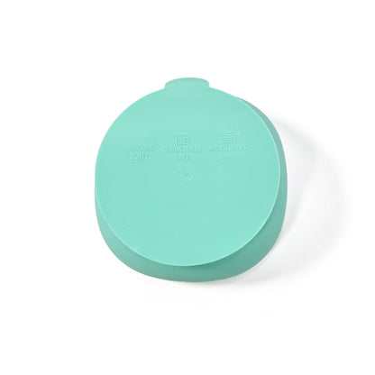 A seafoam green silicone children’s feeding bowl with suction cup on the base. View shows the underside of the bowl.