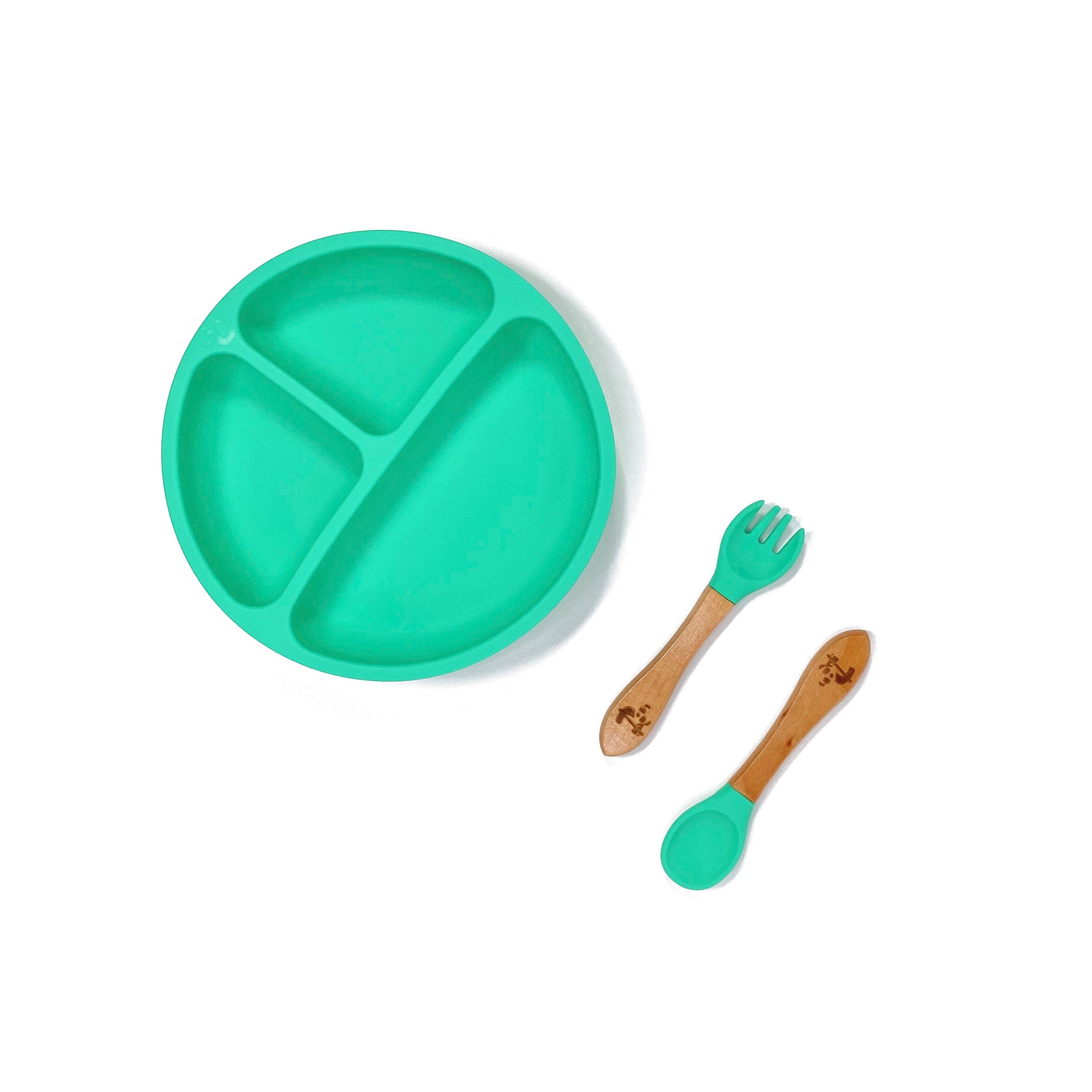 A seafoam green silicone children’s section plate with cups on the base, and matching bamboo and silicone cutlery.