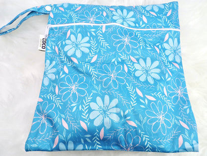 A set of three waterproof bags in a blue floral design, made from bamboo and in three different sizes. Each bag has a zipper closure.  Image shown displays the largest bag with the two smaller bags contained within.