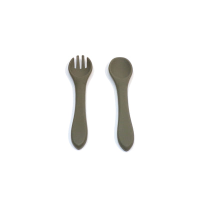 A set of green silicone cutlery, a fork and spoon, designed for young children.