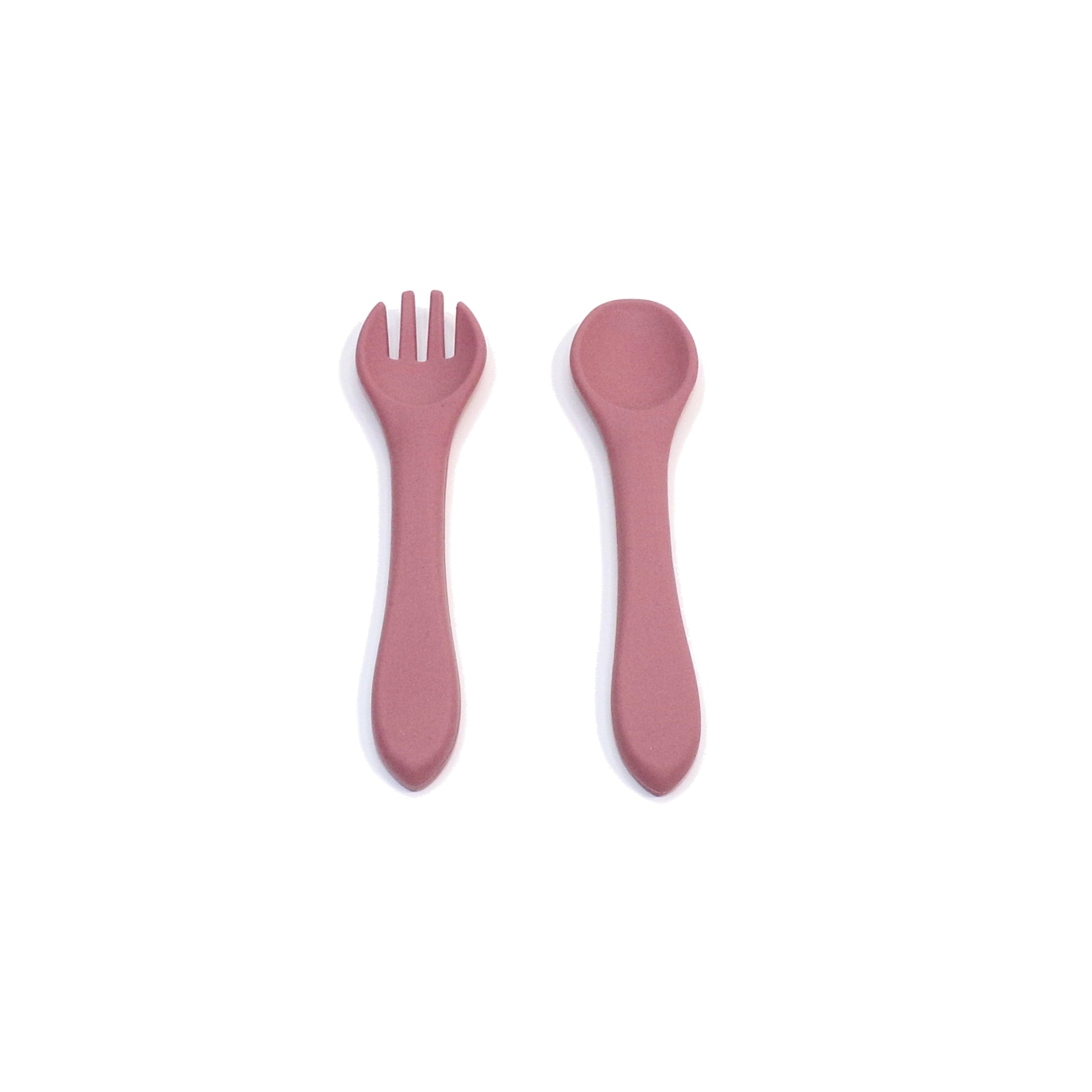 A set of pink silicone cutlery, a fork and spoon. The utensils are designed for young children.
