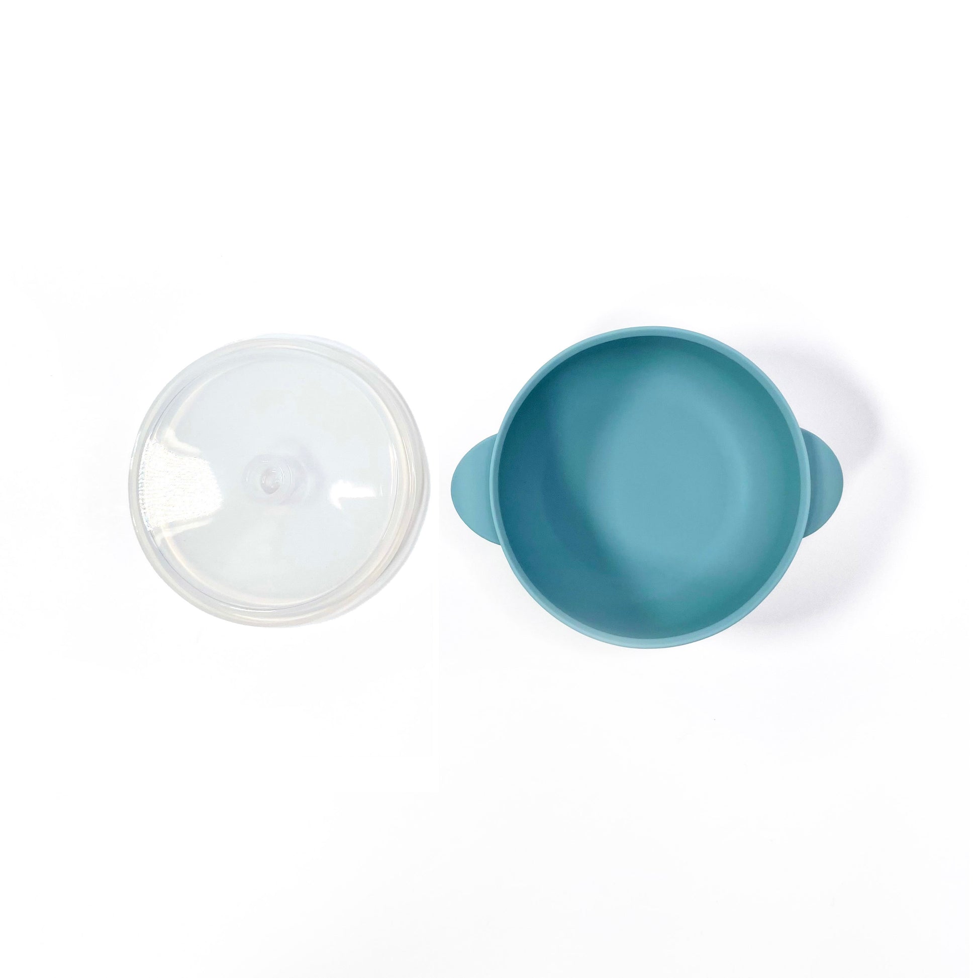 A sky blue silicone children’s feeding bowl, with lid and suction cup. Image shows the bowl with lid separately.