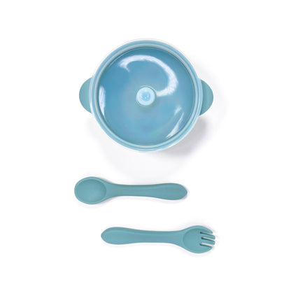 A sky blue silicone children’s feeding set, including silicone bowl with lid and matching silicone cutlery. Image shows the bowl and cutlery from above, with lid attached.