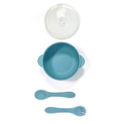 A sky blue silicone children’s feeding set, including silicone bowl with lid and matching silicone cutlery. Image shows the bowl, lid and cutlery separately, from above.