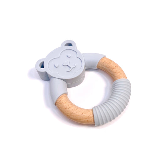 A teething ring made of silicone and bamboo, with a blue monkey design.