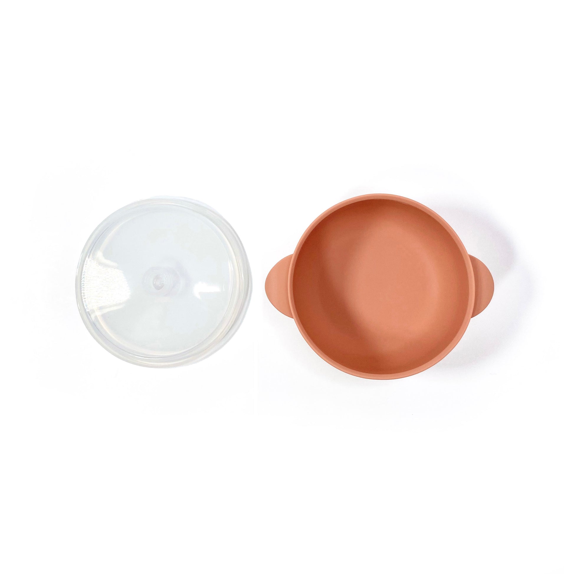 A sunset orange silicone children’s feeding bowl, with lid and suction cup. Image shows the bowl with lid separately.