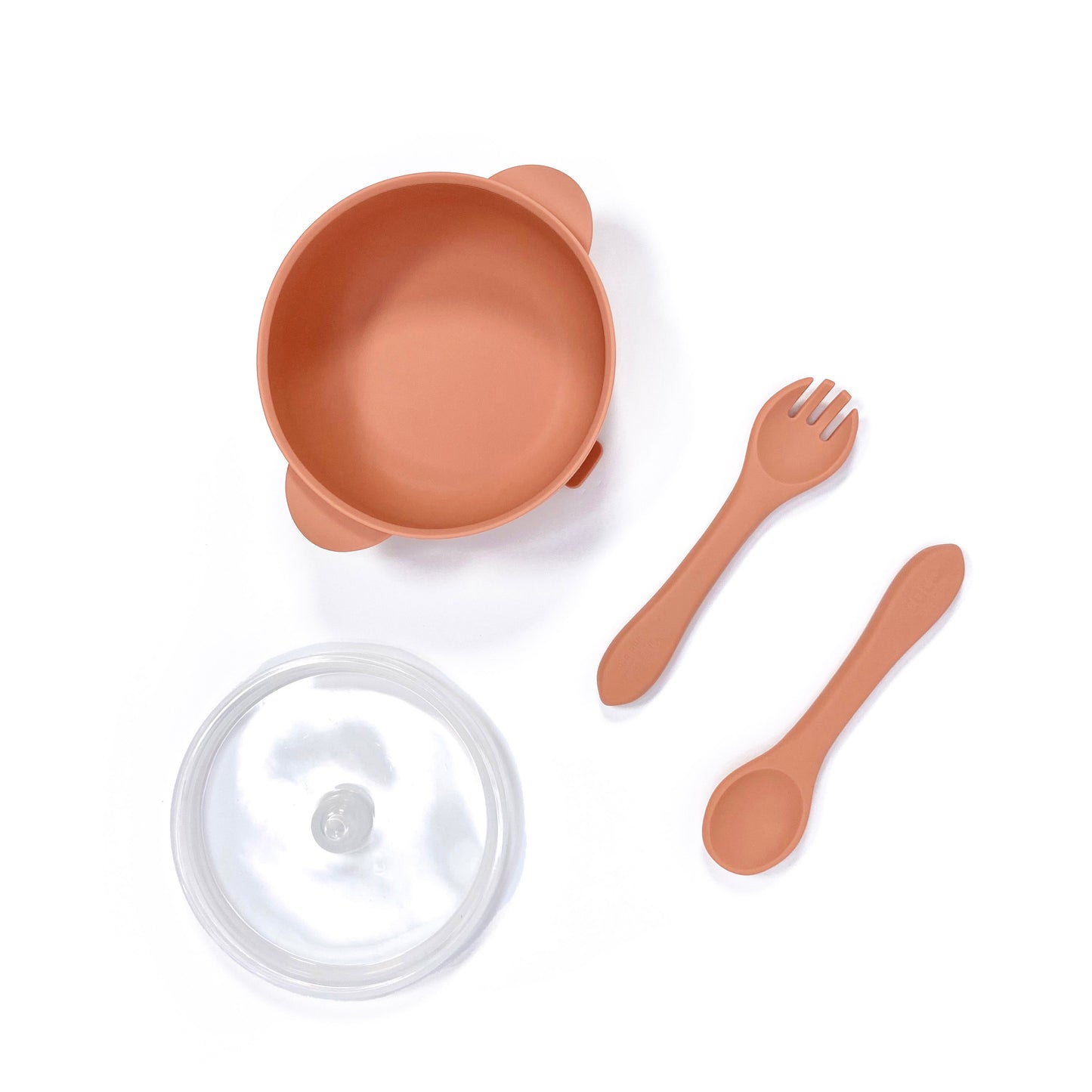 A sunset orange silicone children’s feeding set, including silicone bowl with lid and matching silicone cutlery. Image shows the bowl, lid and cutlery separately, from above.
