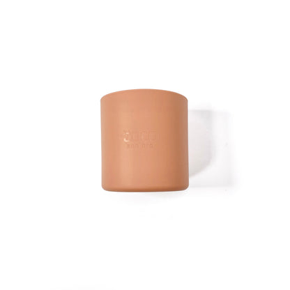 A sunset orange silicone children’s drinking cup. Side view.