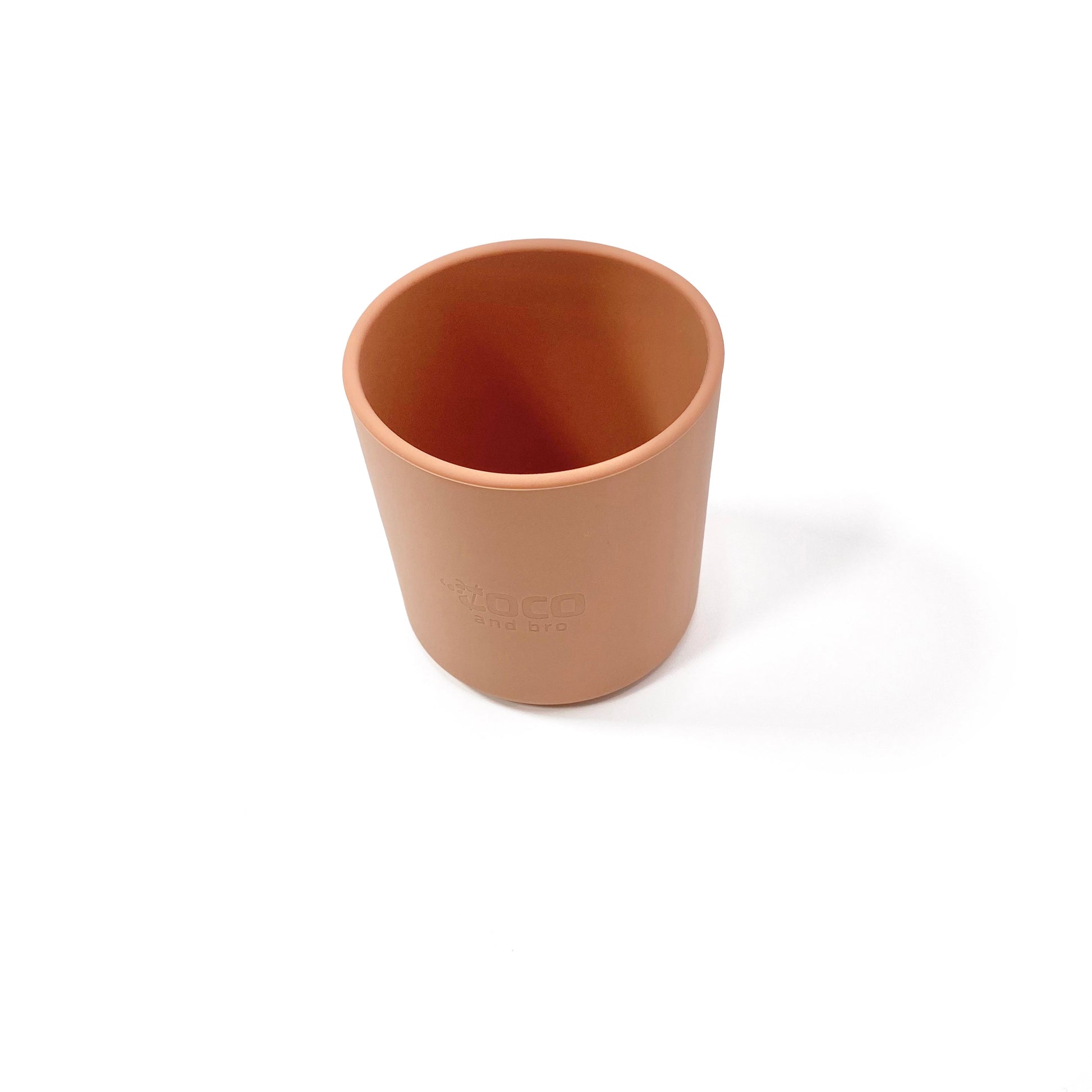 A sunset orange silicone children’s drinking cup. View from above.