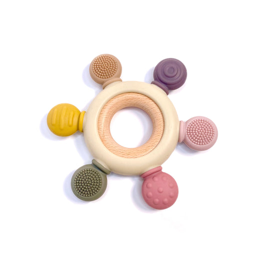 A textured teething ring for babies, made from silicone and bamboo.