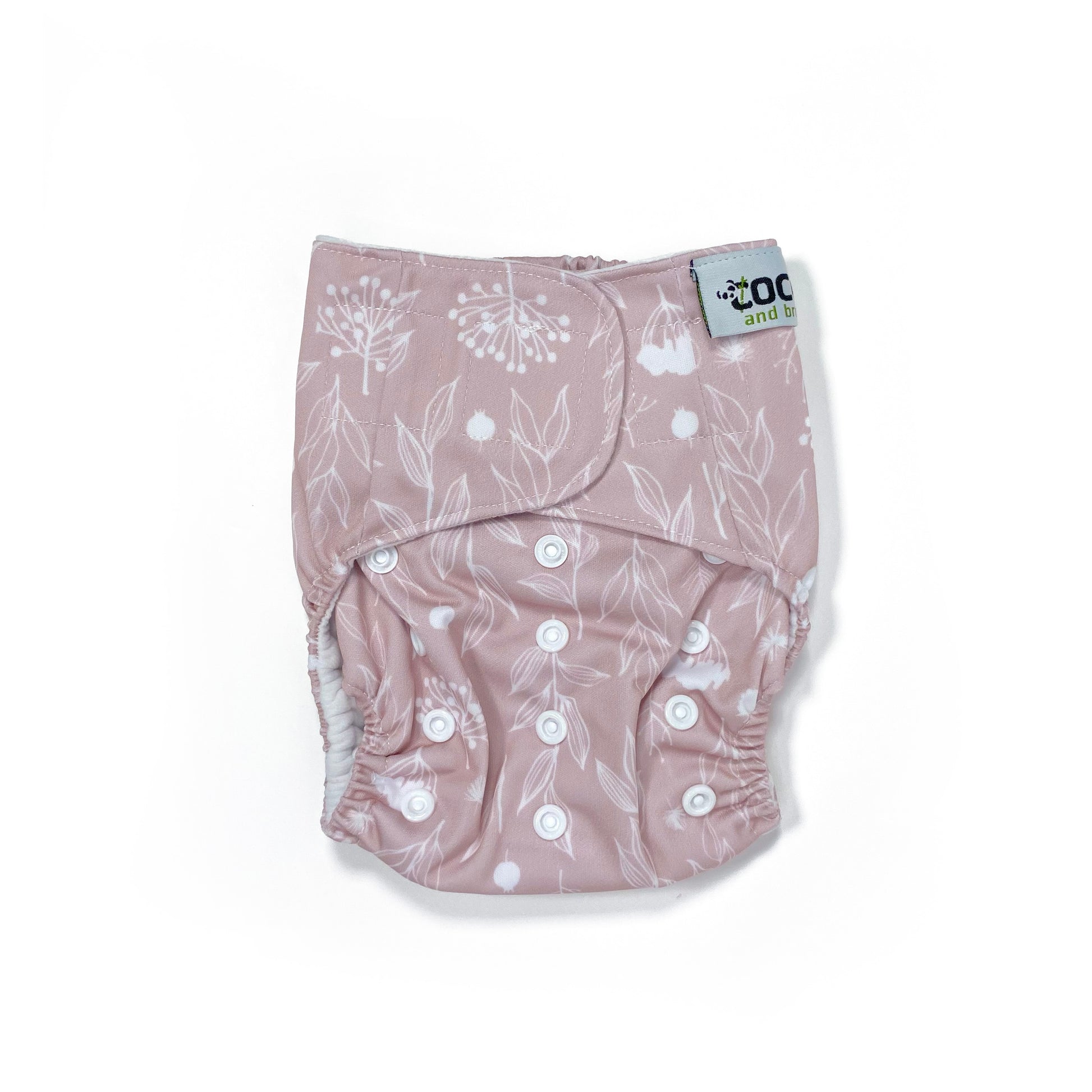 An adjustable reusable nappy for babies and toddlers, featuring a floral lilac design, with floral images on a lilac background. View shows the front of the nappy, with fastenings closed.