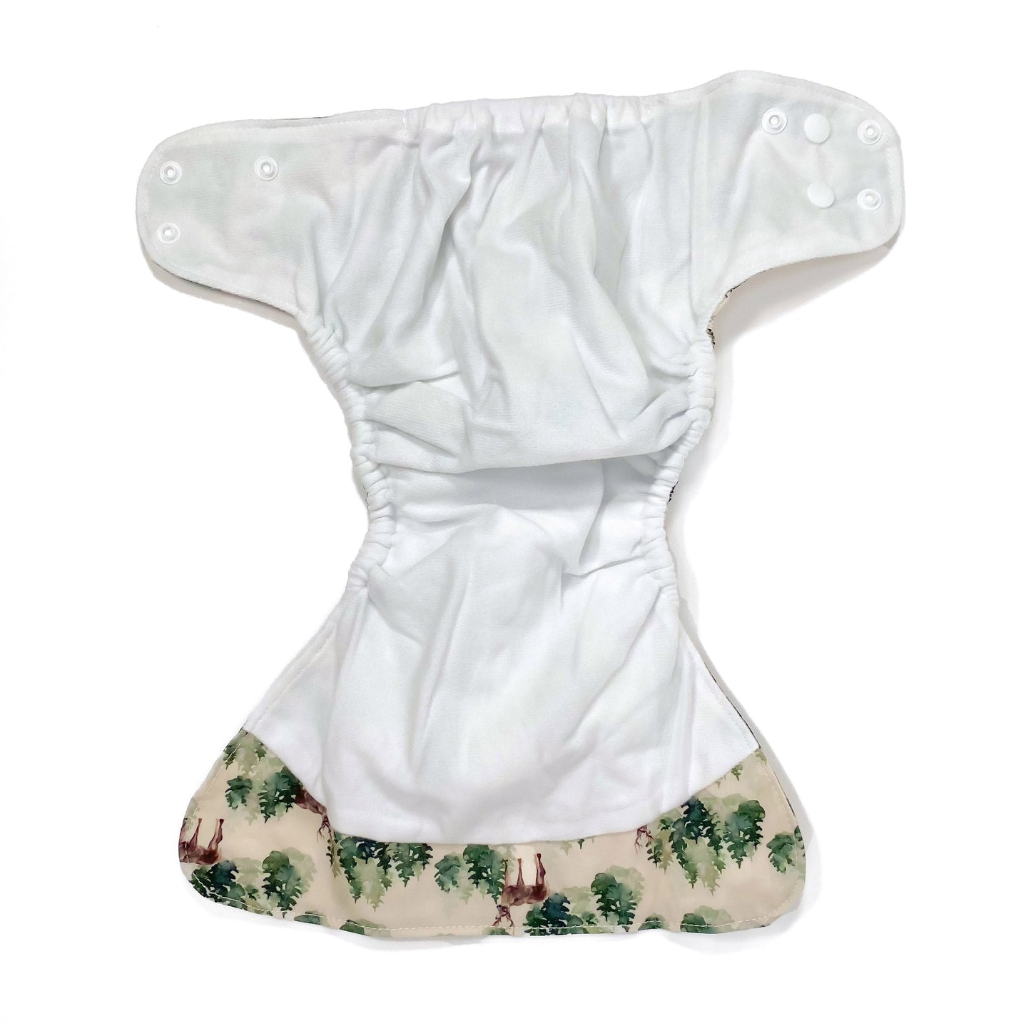 An adjustable reusable nappy for babies and toddlers, featuring a winter forest design with images of deer and pine trees on a cream background. View shows the inside fabric of the nappy.