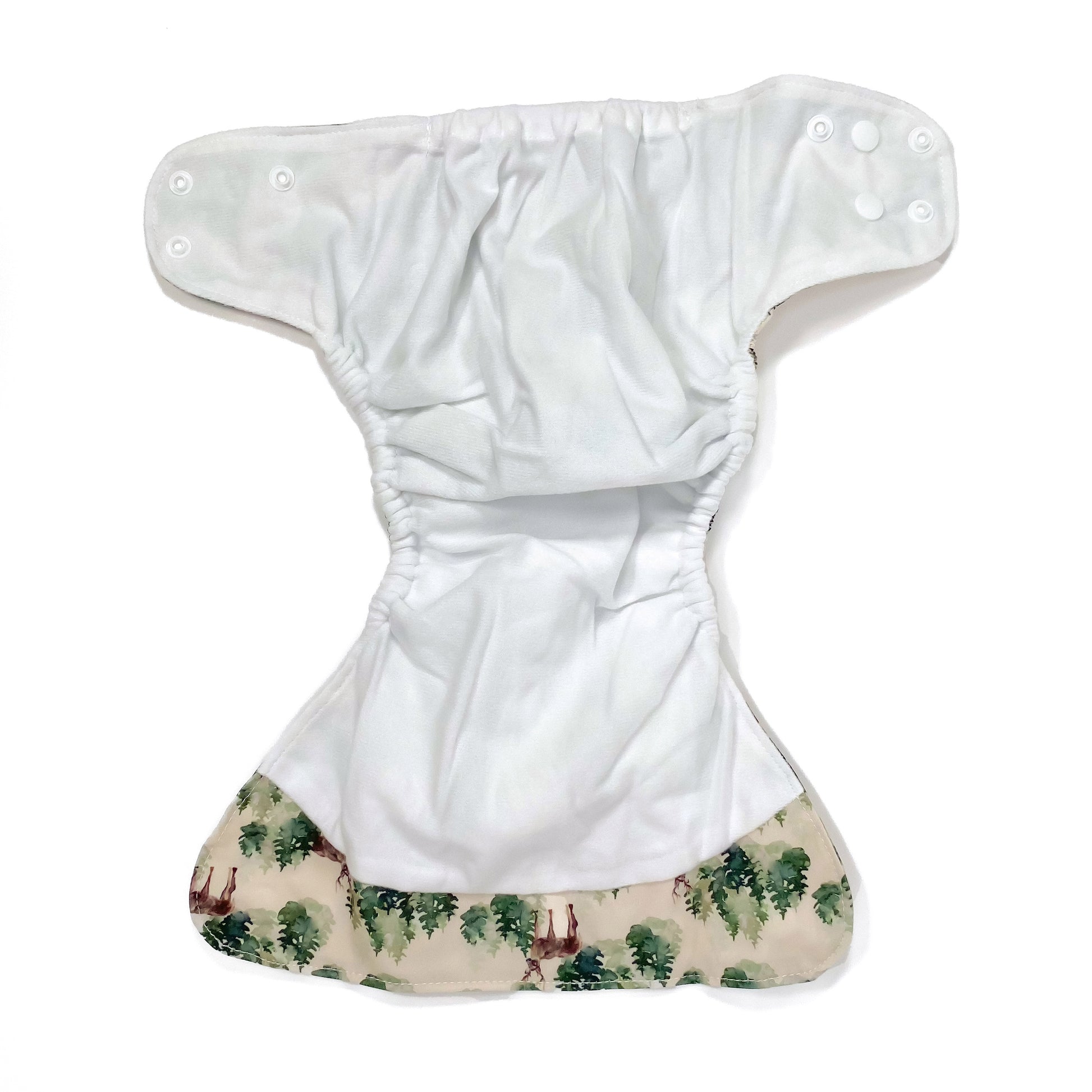 An adjustable reusable nappy for babies and toddlers, featuring a winter forest design with images of deer and pine trees on a cream background. View shows the inside fabric of the nappy.