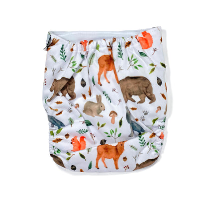 An adjustable reusable nappy for babies and toddlers, featuring a woodland animal design, with images of various woodland animals on a white background. View shows the back of the nappy.
