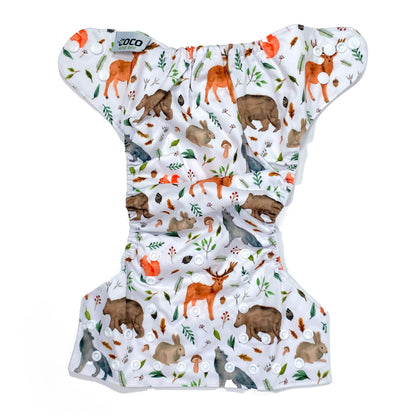 An adjustable reusable nappy for babies and toddlers, featuring a woodland animal design, with images of various woodland animals on a white background. View shows the full outside pattern of the nappy, with fastenings open.