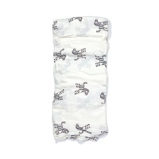A folded muslin swaddle blanket with a zebra design.