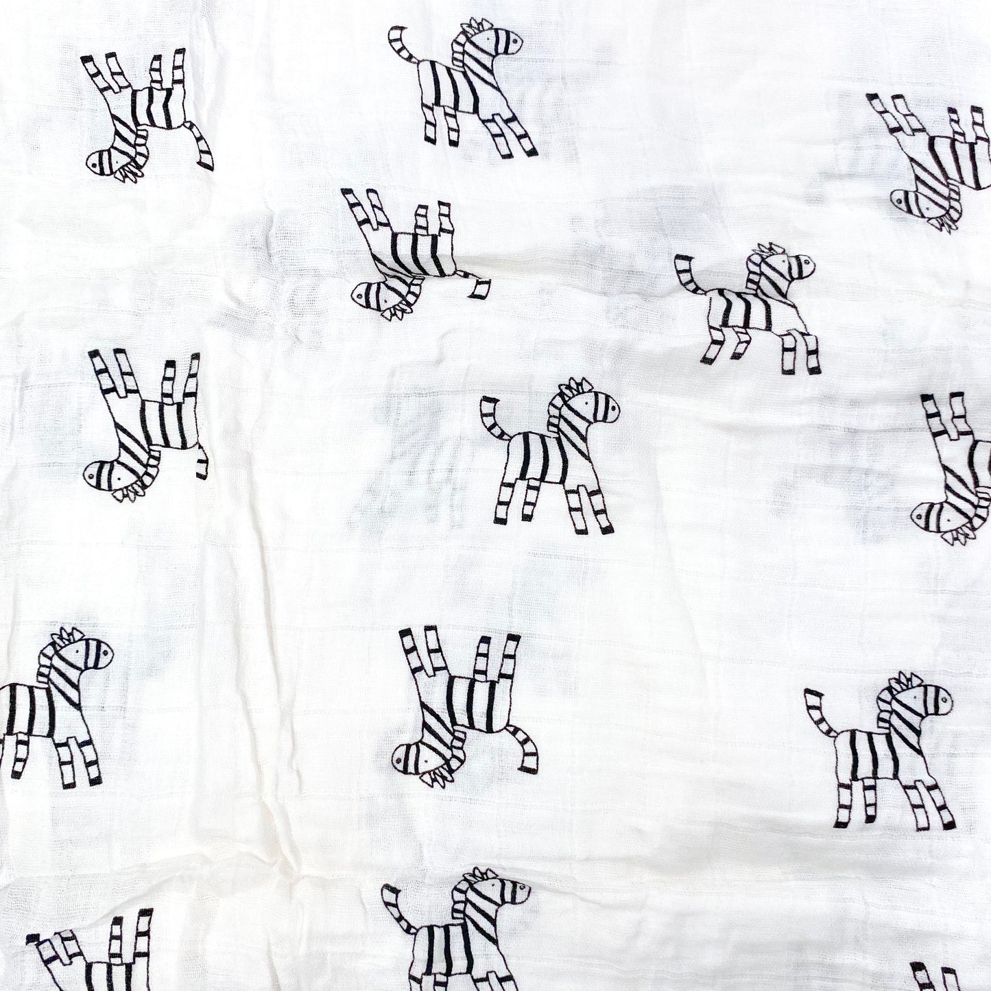 Close up pattern of a muslin swaddle blanket with a zebra design.
