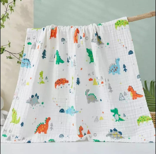 A large muslin baby blanket, made from bamboo and cotton fibres. This blanket is perfect for a baby nursery or out and about in a buggy. The blanket features a cute dinosaur and crocodile pattern.