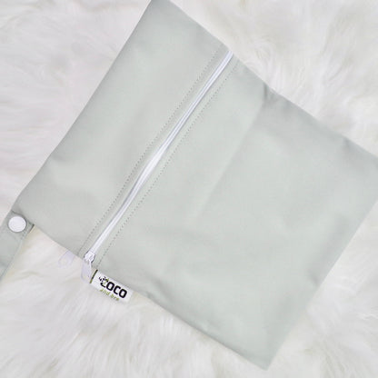 Each backpack purchase includes a free waterproof bag. This image shows the waterproof bag in grey, with a zip closure.