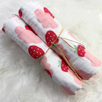 A large muslin baby blanket, made from bamboo and cotton fibres. This blanket is perfect for a baby nursery or out and about in a buggy. The blanket features a cute pink clouds and strawberries pattern.