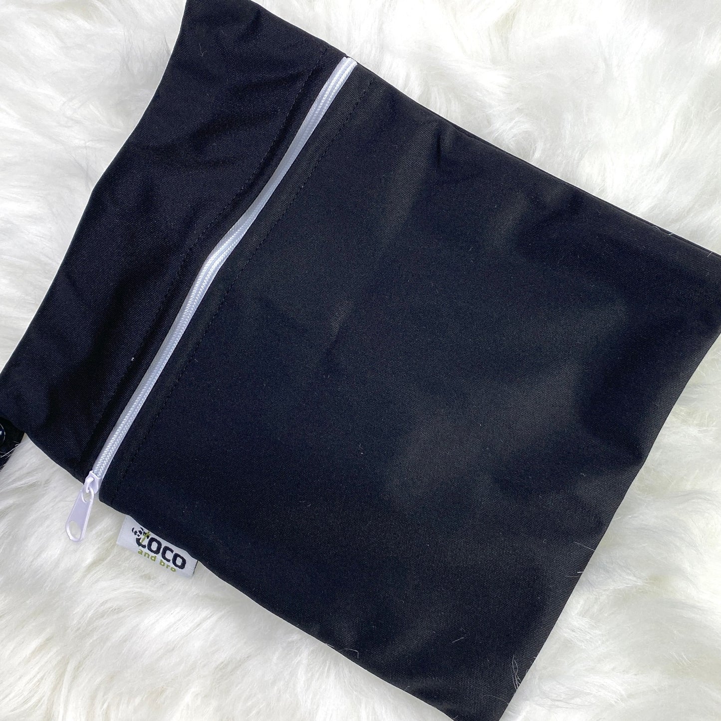Each backpack purchase includes a free waterproof bag. This image shows the waterproof bag in black, with a zip closure.
