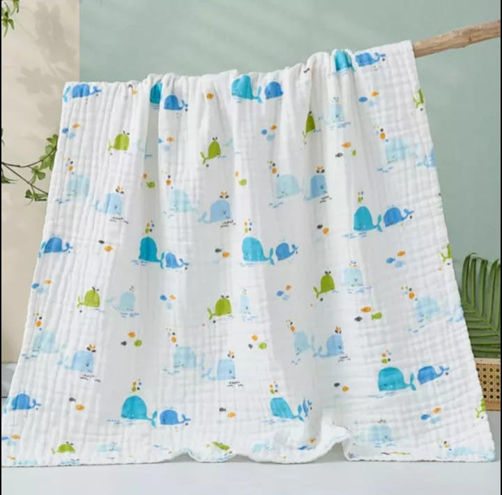 A large muslin baby blanket, made from bamboo and cotton fibres. This blanket is perfect for a baby nursery or out and about in a buggy. The blanket features a cute whale pattern.